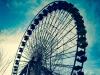 An old Ferris wheel in an old amusement park.